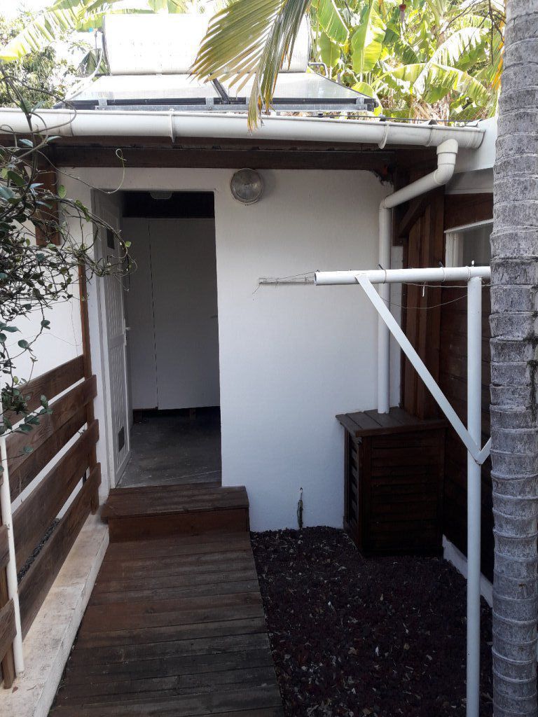 Entrée du local commun (T1 et T2) avec cellier privatif pour chacun (la porte au fond est le cellier du T1) et machine à laver commune neuve (vedette 1200 tours).
A droite l'étendeur pour le linge.
A gauche le jardinet du T2
